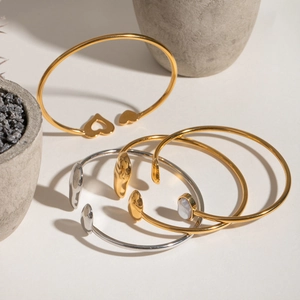 Minimalist irregular open bangles in gold and silver finish with heart and pearl accents