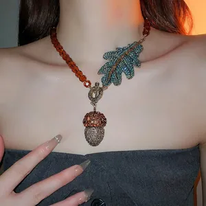 Collier pendentif gland vintage avec perles ambre et feuille en strass bleus sur mannequin