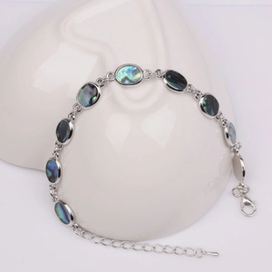 Detail of silver chain bracelet with oval abalone shell charms and lobster clasp