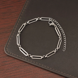 Detailed shot of silver stainless steel chain bracelet with rectangular links on leather