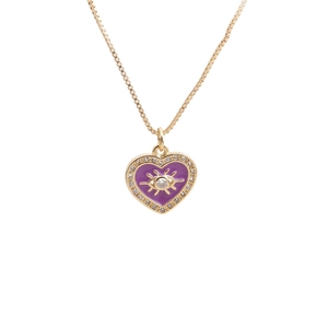Detail of gold heart pendant with purple enamel eye motif and zircon setting
