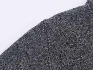 Macro detail of dark grey knit fabric with shiny silver lurex threads and soft texture