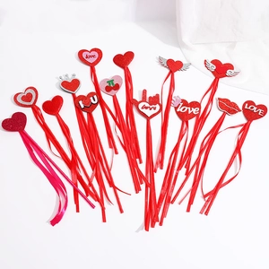 Close-up of red sequin heart wands with ribbons, crowns and wings for Valentine's Day decor