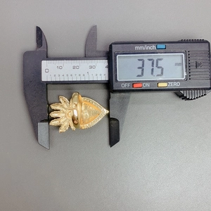 Detailed macro view showing the 37.5mm measurement of the gold heart wing ring with a caliper