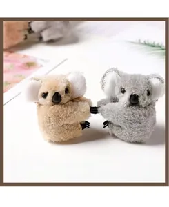 Close-up of adorable plush koala hair clips in grey and light brown with soft texture