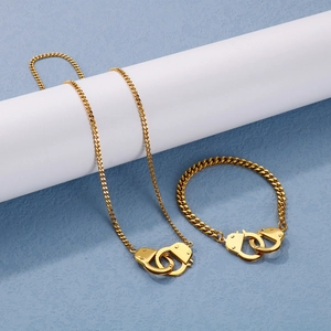 Close-up of golden handcuffs necklace and bracelet set with chunky Cuban chain