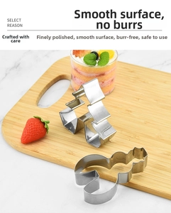 Detailed view of stainless steel Christmas cookie cutters on a wooden board
