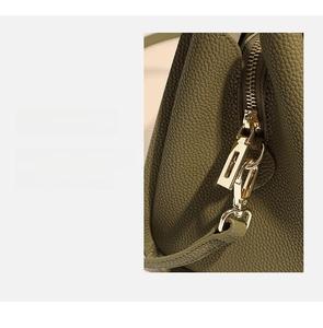 Close-up of green lychee leather texture and golden metal lobster clasp hardware