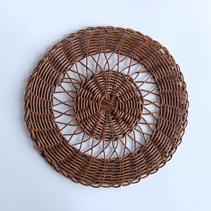 Handgewebte runde Wanddeko aus dunkelbraunem Rattan für bohème Schlafzimmergestaltung