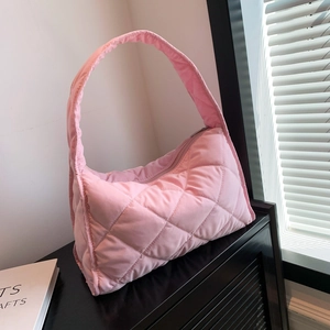 Close-up of pink quilted nylon shoulder bag with soft padding on a display shelf