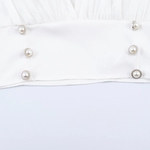 Blouse élégante blanche de style français avec col en V et détails de boutons perlés
