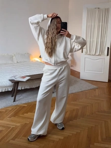 Women's white two-piece lounge set with zip-up hoodie and wide-leg drawstring sweatpants