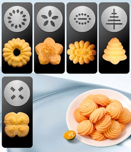 Detail of stainless steel cookie press discs and freshly baked shaped butter biscuits