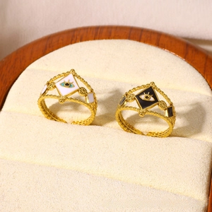 Detail of adjustable gold evil eye rings with black and white enamel in a velvet box
