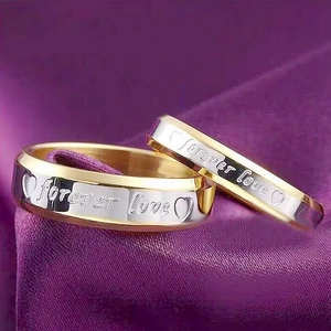 Macro detail of bicolour gold and silver titanium rings with Forever Love engraving