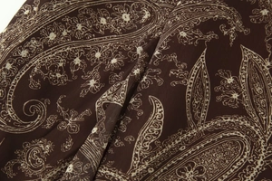 Détail rapproché du motif paisley beige sur un tissu léger de couleur marron café