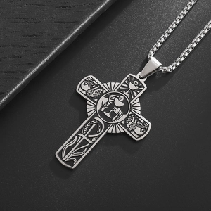 Detail of silver stainless steel cross pendant with intricate religious vine engravings