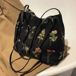 Large capacity black canvas bucket bag featuring detailed colorful floral embroidery