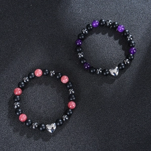 8mm schwarze matte Achatperlen-Armbänder mit Herzanhänger auf schwarzem Hintergrund
