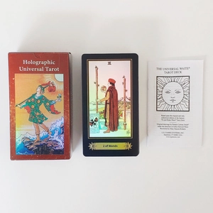 Close-up of holographic tarot set including card, colorful box and instruction manual