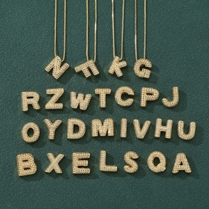 Macro shot of 26 gold A-Z bubble letter pendants with sparkling micro-inlaid zircon stones