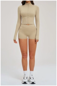 Detail of high-waisted shorts with V-cross waistband in a ribbed sand-colored gym set