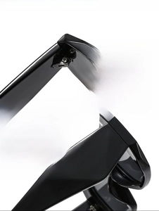 Macro view of durable metal hinges and geometric faceted frame of black square sunglasses