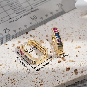 Detail shot of gold rectangular earrings with size measurements on stone background