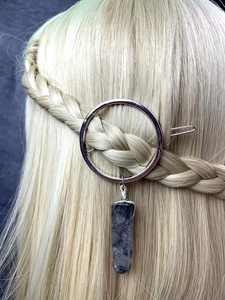 Detail of silver circular hair clip with natural black crystal pendant on braided hair