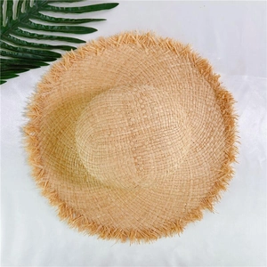 Vue de dessus d'un chapeau de paille à larges bords avec franges sur fond blanc