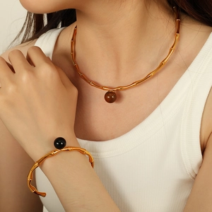 Minimalist gold bamboo choker necklace and bracelet set with marble and black bead accents
