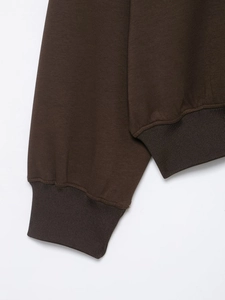 Detail shot of the dark brown ribbed cuffs and hem on the casual athletic tracksuit