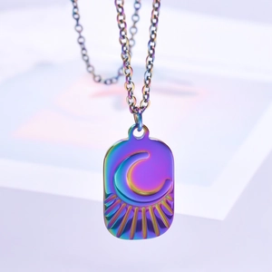 Macro shot of rainbow-plated stainless steel moon pendant necklace with radial lines detail