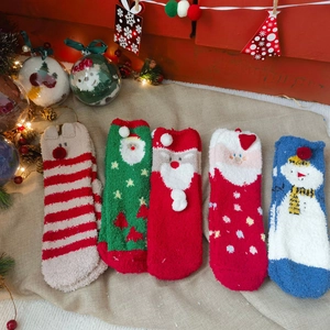 Festive fuzzy Christmas socks with various holiday patterns on a warm rustic background