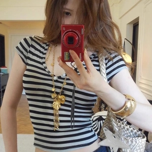 Long gold shell tassel necklace in vintage French style worn with a striped t-shirt