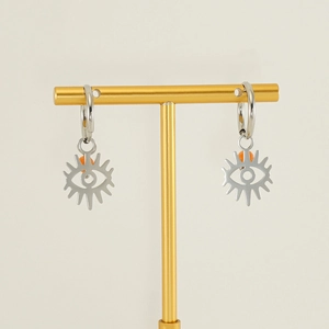 Detail of silver hoop earrings featuring a sun eye pendant with a bright orange bead