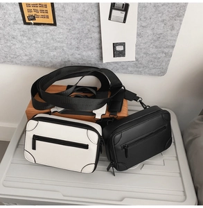 Detail of minimalist black and white crossbody box bags with wide nylon straps and zip pockets