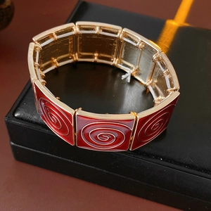 Detailed macro shot of vintage square red enamel and gold-plated textured bracelet