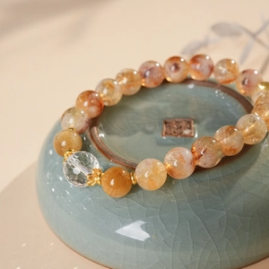 Macro detail of golden rutilated quartz beaded bracelet on a porcelain bowl base