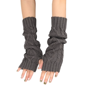 Macro view of dark grey cable knit fingerless gloves with soft wool texture and patterns