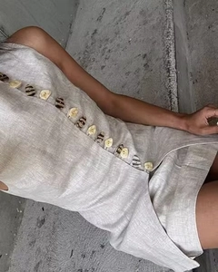 Detail of linen sleeveless top with unique diagonal placket and assorted shell buttons