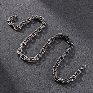 Détail du collier chaîne hip-hop argenté vintage sur une surface en cuir noir fine