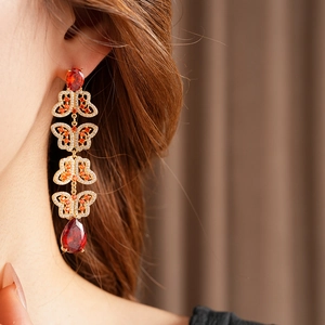 Détail de boucles d'oreilles vintage papillon avec zircons rouges sur un mannequin