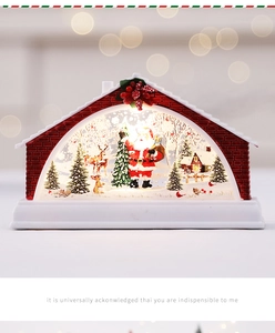 Detail of a red brick Christmas house lantern with Santa, reindeer and LED lighting