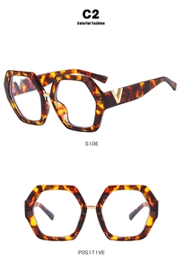 Detail of tortoise shell polygonal frames with gold V-shaped metal logo on temples