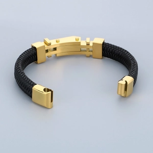Dettaglio del bracciale da uomo in pelle nera intrecciata con finiture in metallo dorato