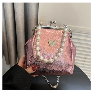 Detail of pink glitter evening bag featuring a pearl handle and butterfly clasp