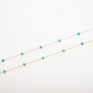 Chaîne en acier plaqué or 18K avec perles turquoise sur fond blanc pur