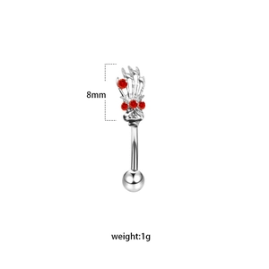 Detail of 8mm stainless steel eyebrow piercing with silver skull hand and red crystals