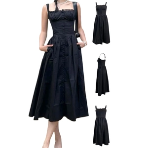 Détails d'une robe noire à bretelles avec bordure en dentelle et boutons décoratifs